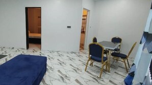 Quarto com cama, escrivaninha, cadeira e televisão.