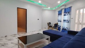 Uma sala de estar moderna com um sofá, uma mesa de centro e uma área de jantar com cadeiras.