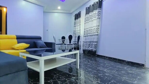 Een moderne woonkamer met een bank, fauteuil en salontafel.