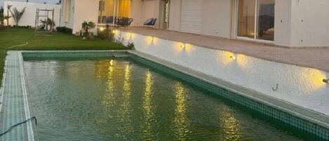 Una piscina al aire libre, una piscina climatizada