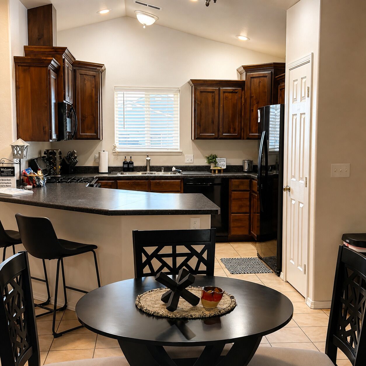 A kitchen with wooden cabinets, a central island, and a dining area with a table and chairs.