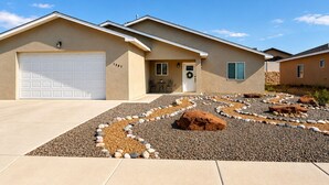 A residential building with a garage, a front door, and a small porch area.