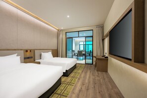 A hotel room with two beds, a flat-screen TV, a desk, and a view of the outside. - Holiday Inn Jiuhua Mountain Hot Spring by IHG (Chizhou)