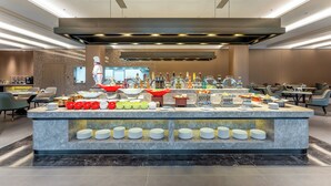 A modern breakfast bar with a variety of food items and beverages, surrounded by seating areas. - Holiday Inn Jiuhua Mountain Hot Spring by IHG (Chizhou)