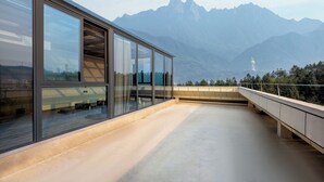 A modern building with large windows overlooking a mountainous landscape. - Holiday Inn Jiuhua Mountain Hot Spring by IHG (Chizhou)
