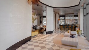 A modern hotel lobby with a checkered floor, a bar area, and seating arrangements. - voco Suites Shanghai Hongqiao CBD by IHG (Shanghai)