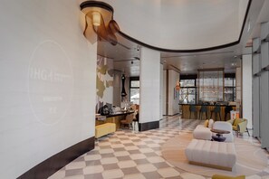 Un moderno vestíbulo de hotel con suelo a cuadros, una zona de bar y arreglos de asientos.
