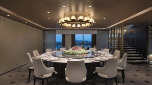 A modern dining room with a round table set for six, surrounded by six chairs. - voco Suites Shanghai Hongqiao CBD by IHG (Shanghai)
