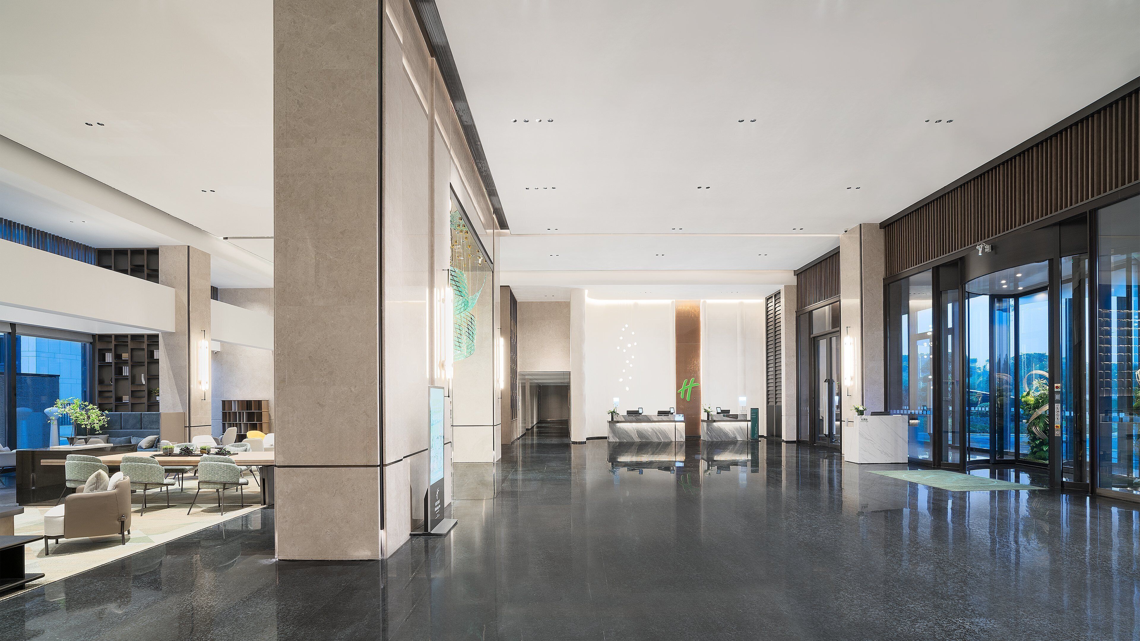 A spacious lobby with a reception desk, seating area, and large windows offering views.
