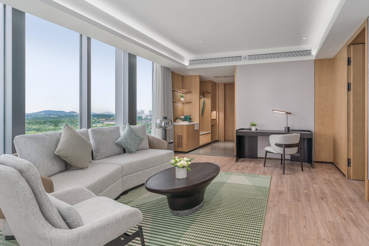 A modern living room with a sofa, coffee table, and a desk area.