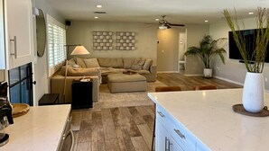 A modern kitchen with a large island, a dining area with a table and chairs, and a living room with a sofa and a coffee table. - Arcadia oasis Heated Pool (Phoenix)