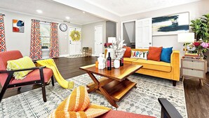 A living room with a sofa, armchair, coffee table, and decorative items.