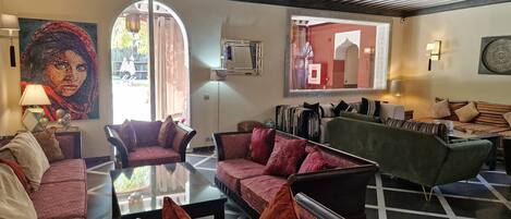 A spacious living area with multiple seating options, including sofas and armchairs, arranged around a central coffee table.