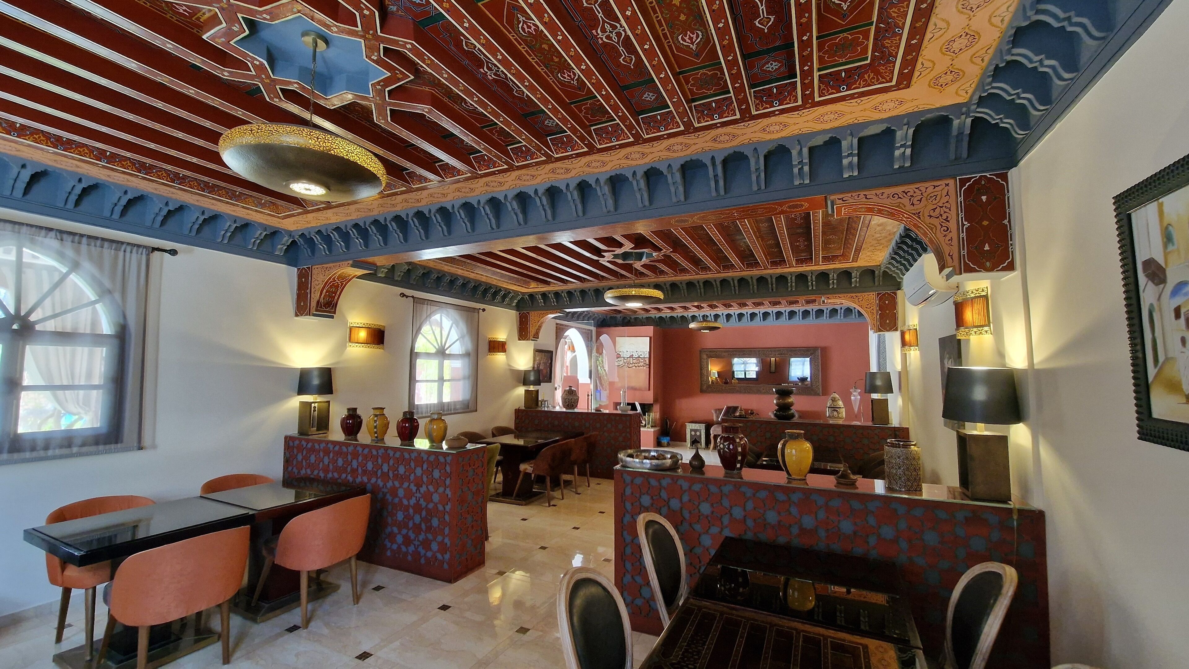 En restaurant med traditionel indretning, blandt andet tapetvægge og -loft, samt forskellige sidearrangementer.