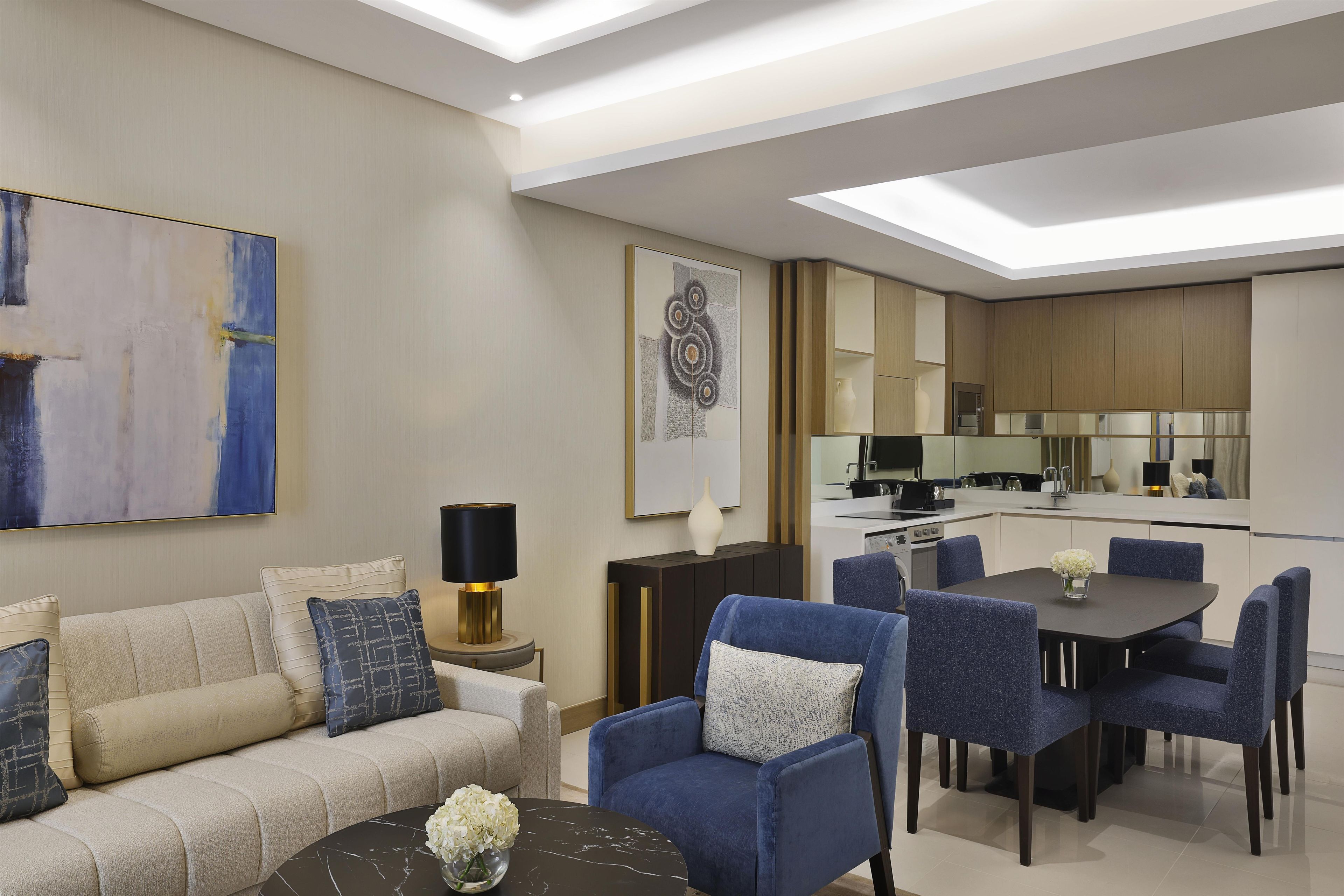 Un salon moderne avec un canapé, une table basse et des fauteuils bleus.