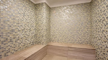 A bathroom with mosaic tile walls and wooden benches.