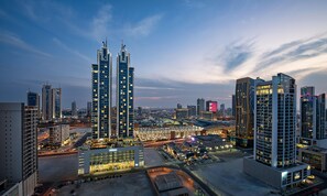 Ein Hochhaus-Hotel mit mehreren Stockwerken, einem Parkplatz und umliegenden Stadtgebäuden.