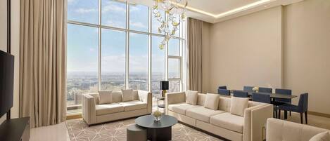 A spacious living room with a large window, a chandelier, and a city view.