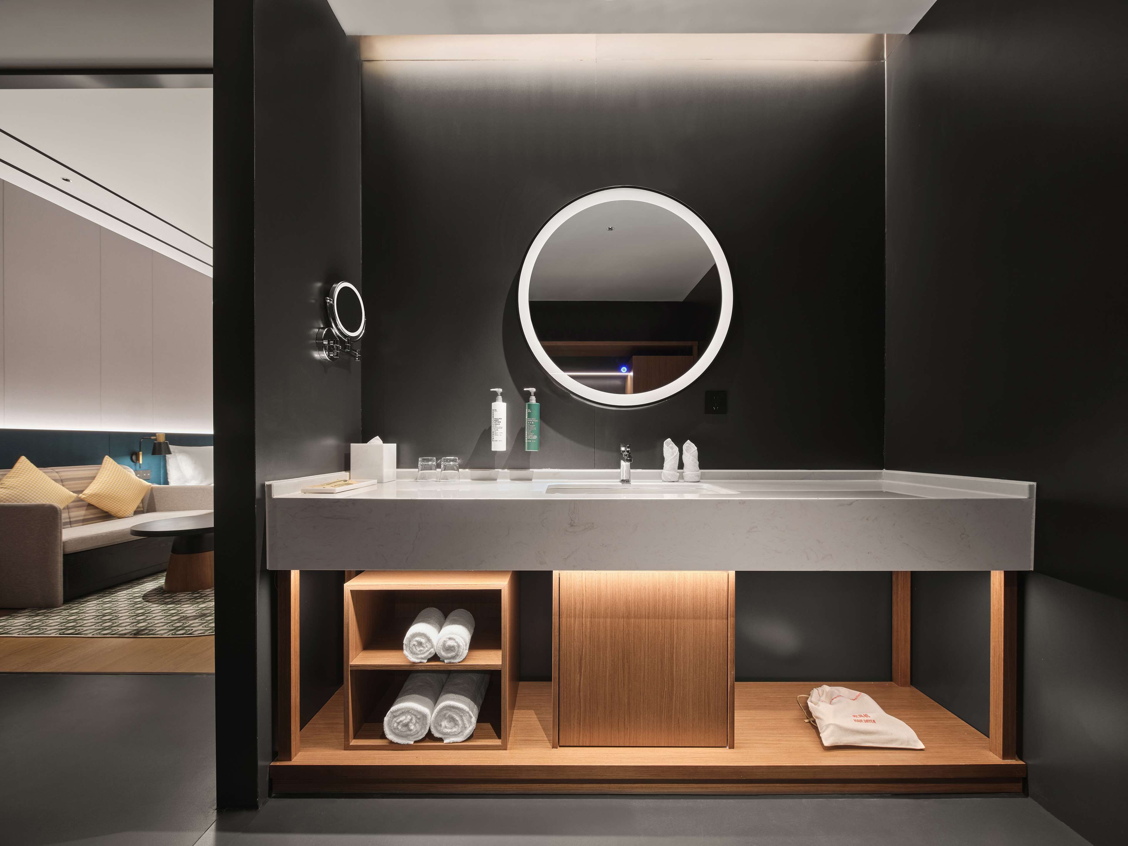 A modern bathroom with a large mirror, built-in shelves, and a sleek design.