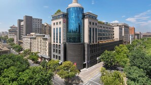 A modern building with a distinctive glass tower and traditional architecture. - Hilton Garden Inn Xi'An Bell Tower (Xi'an)