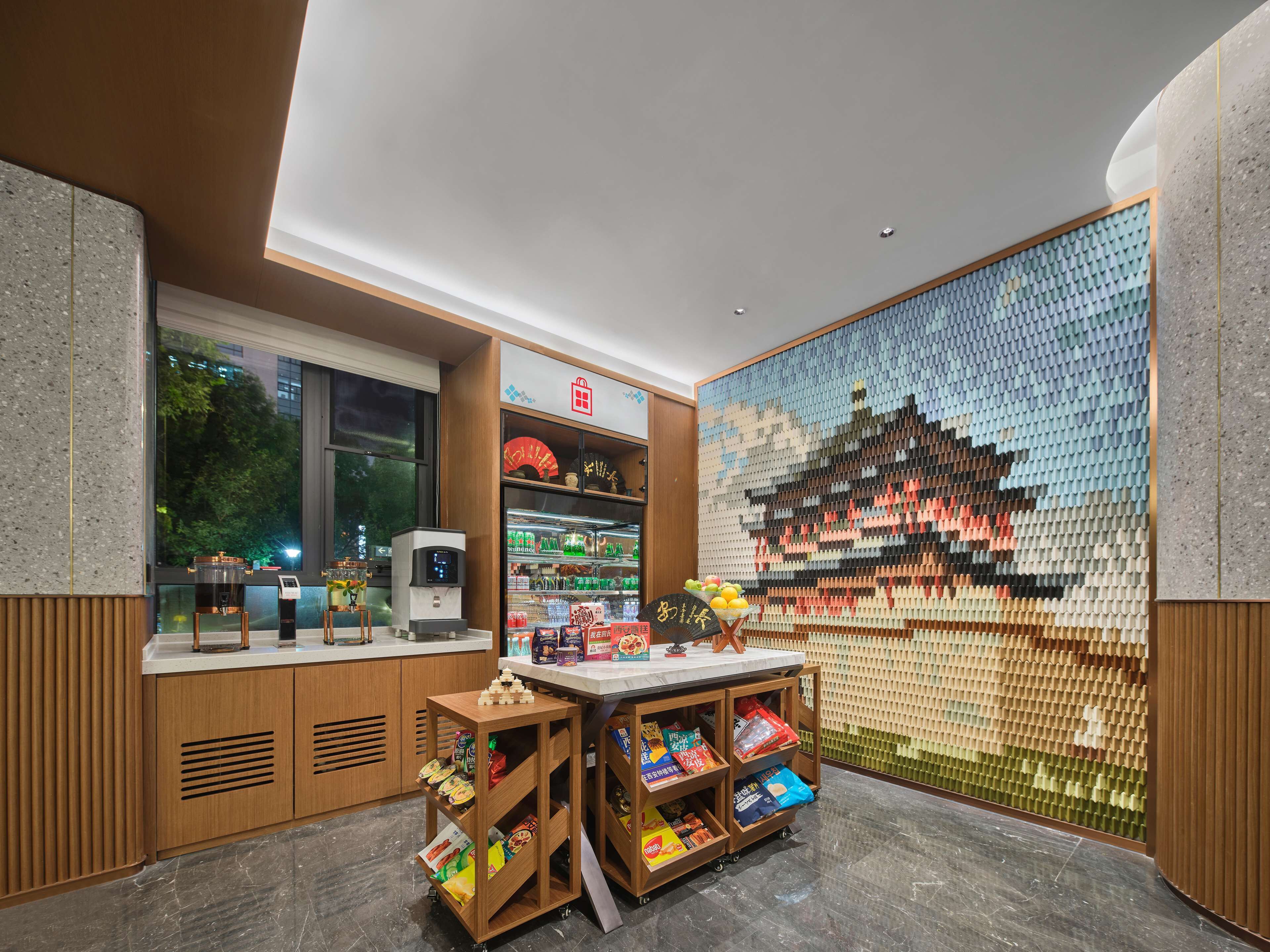 Un intérieur moderne agrémenté d’une machine à café, d’étagères pour les collations et d’une œuvre d’art murale.