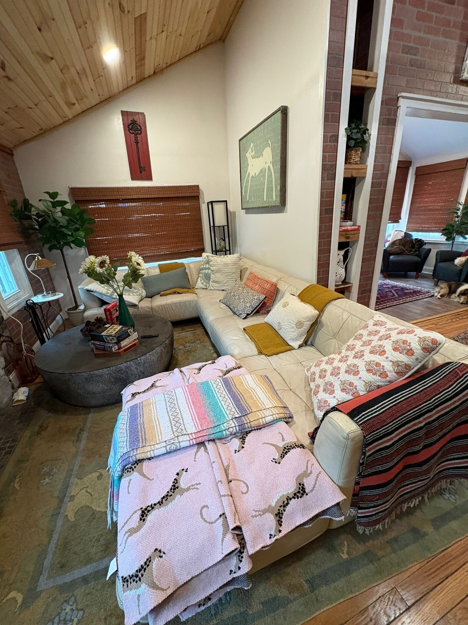 En hyggelig stue med en hjørnesofa, et sofabord og en pejs.