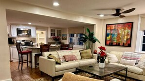 A living room with a sofa, coffee table, and a dining area with chairs and a table. - The Old Avon Village (Avon)