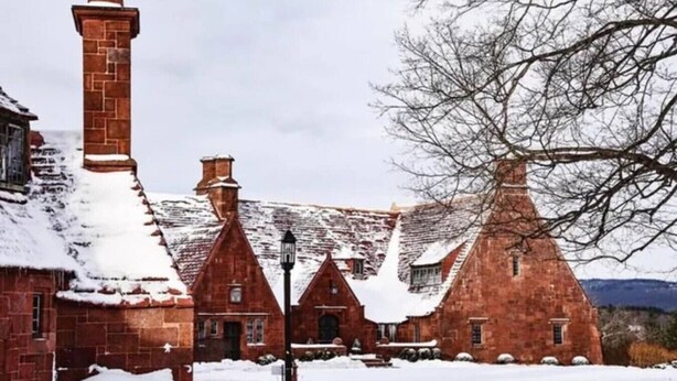 A historic building with red brick architecture, snow-covered roofs, and a prominent chimney. - The Old Avon Village (Avon)