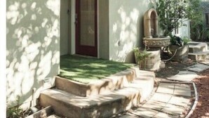 A house with a red door, a small porch, and a garden area with steps leading to the door. - Serene Escape 2BD /w Private Patio near Stanford (Menlo Park)