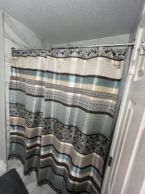 A shower curtain with a striped pattern and floral designs.