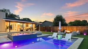 Ein modernes Haus mit Swimmingpool, Sitzgelegenheiten im Freien und einem Holzzaun.