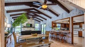 A spacious living area with a wooden dining table, a sofa, and a large potted plant. - Farmhouse Oasis Retreat in Homestead (Homestead)