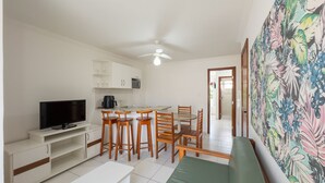 Kompakti oleskelutila, jossa on pieni keittiö, ruokailualue, televisio ja sohva.