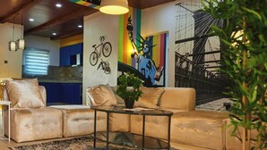 A modern living room with a sofa, a coffee table, and a mural of a bicycle and a statue. - Spirit of India Lagos (Lagos)