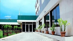 A building with a green awning, potted plants, and a paved entrance area. - Spirit of India Lagos (Lagos)