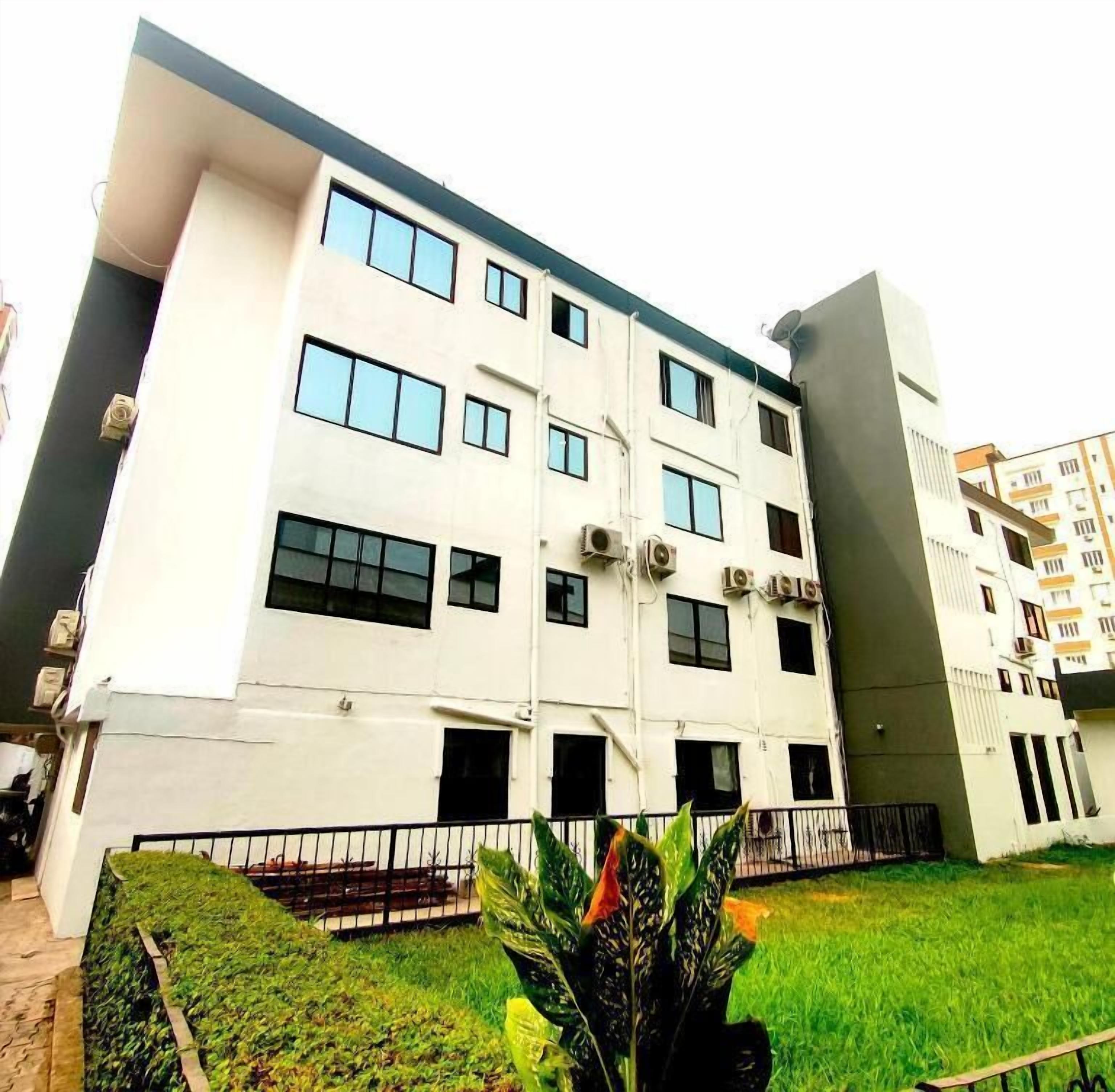 A multi-story building with a flat facade, multiple windows, and air conditioning units.