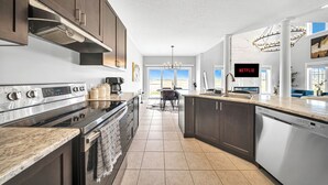 A modern kitchen with stainless steel appliances, dark cabinetry, and a large island. - Lavish Home on Hamilton Mountain- King Bed (Hamilton)