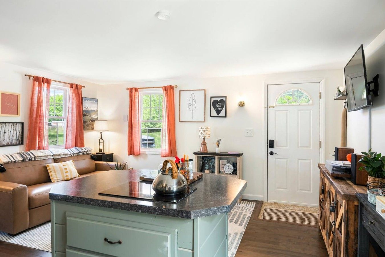 A living room with a sofa, a coffee table, and a kitchen area with a countertop.