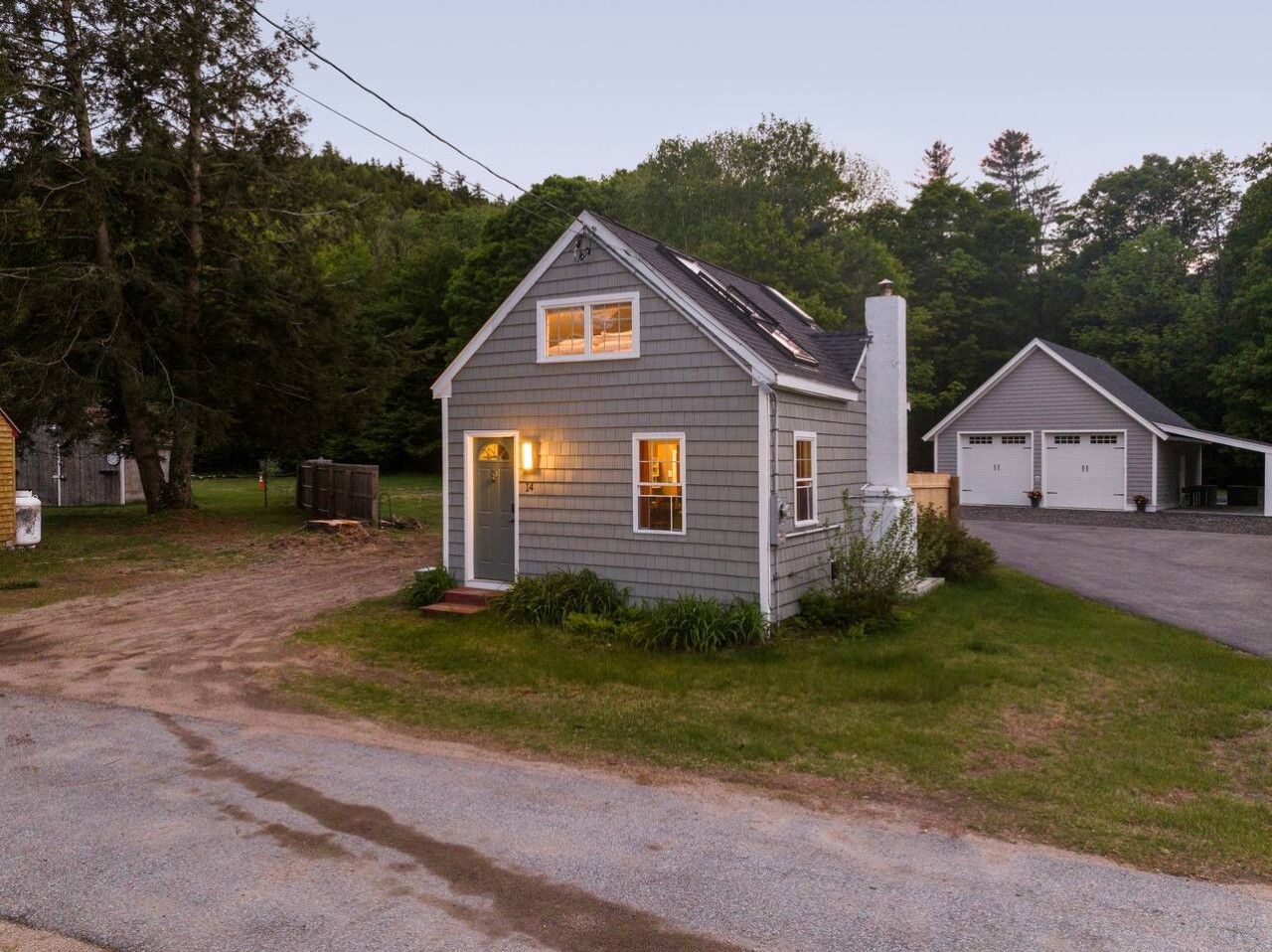 A two-story house with a garage, a front porch, and a driveway.