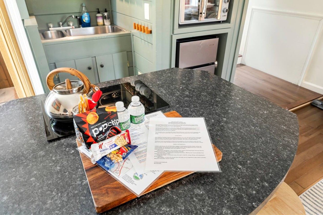 A kitchen counter with a pop-up toaster, a kettle, and a magazine.