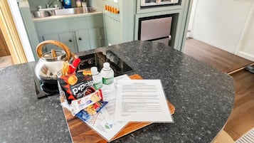 A kitchen counter with a pop-up toaster, a kettle, and a magazine.