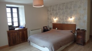 A bedroom with a large bed, wooden headboard, bedside tables, a radiator, and a window with blinds. - Spacious 5-bedroom house in enchanting Luz-Saint-Sauveur 
 (Luz-Saint-Sauveur)