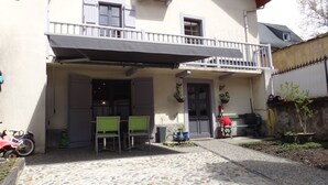 A two-story building with a balcony, outdoor seating area, and potted plants. - Spacious 5-bedroom house in enchanting Luz-Saint-Sauveur 
 (Luz-Saint-Sauveur)