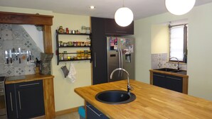 A modern kitchen with wooden countertops, a built-in sink, and a refrigerator. - Spacious 5-bedroom house in enchanting Luz-Saint-Sauveur 
 (Luz-Saint-Sauveur)
