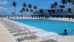 A pool area with sun loungers and a clear view of the ocean. - Cute Studio Bay view! (Miami)