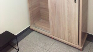 A wooden wardrobe with a door, a blue hanger, and a small black stool. - private room near taxi station and airport 
 (Inezgane)