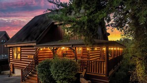 Une cabane en rondins dotée d’une véranda, d’un escalier en bois et d’une enseigne indiquant qu’il s’agit d’un restaurant.