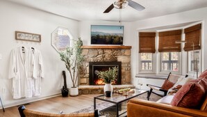 A cozy living room with a fireplace, a mounted TV, and a comfortable seating area. - Romantic cabin with Sauna, fitness room in Gatlinburg, near NP, Pet-Friendly (Gatlinburg)