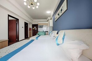 A hotel room with a large bed, a blue accent wall, and a ceiling light fixture. - Aiqinghai apartment (Guangzhou)