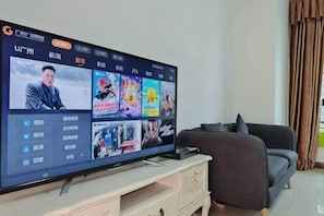 A television on a stand with a user interface displaying various content options.